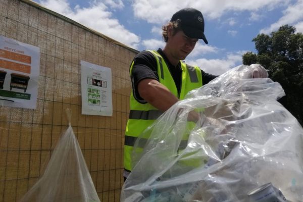 Man in safety vest sorting through plastics